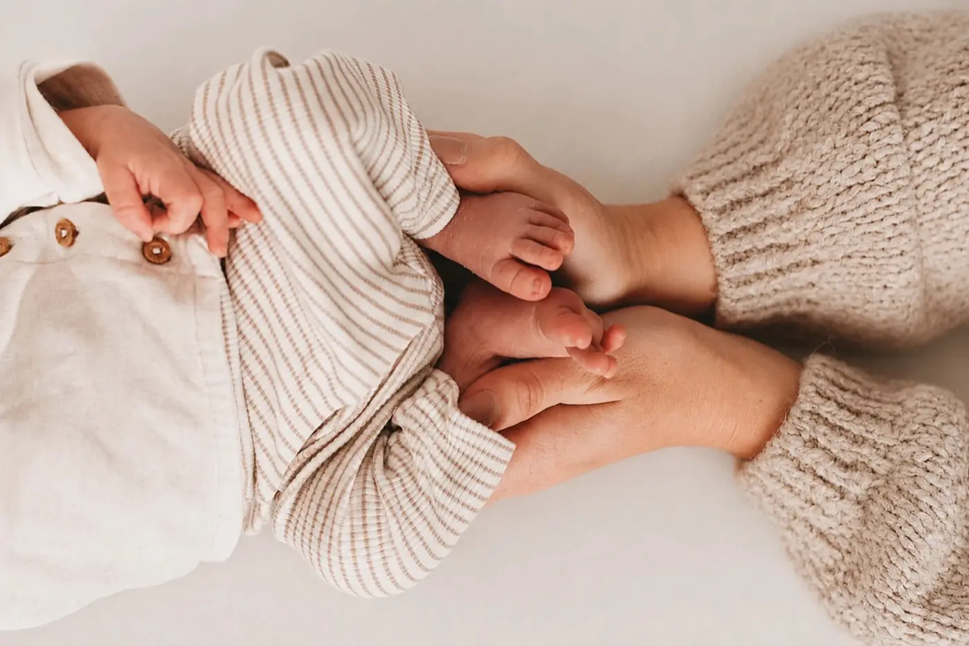 Babyfüße in den Händen der Eltern