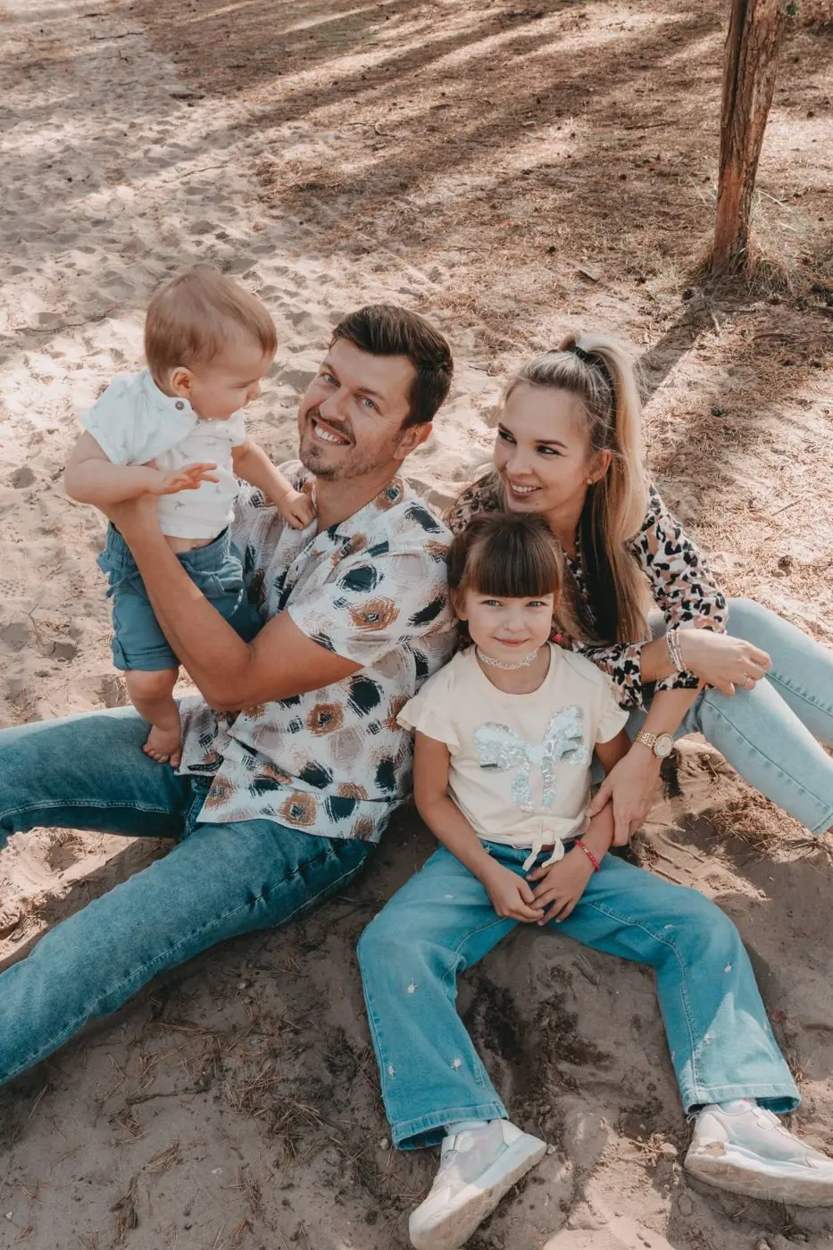 Familie mit zwei Kindern im Sand