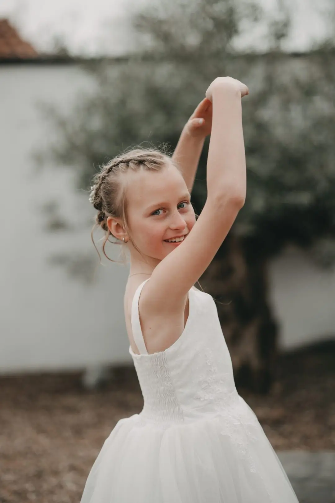Mädchen im weißen Kleid tanzt im Garten